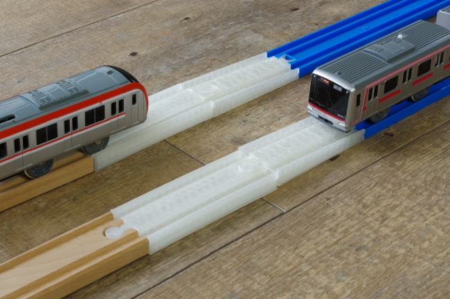 木製の線路とプラレールの相互通運転を可能にする線路（使用イメージ）